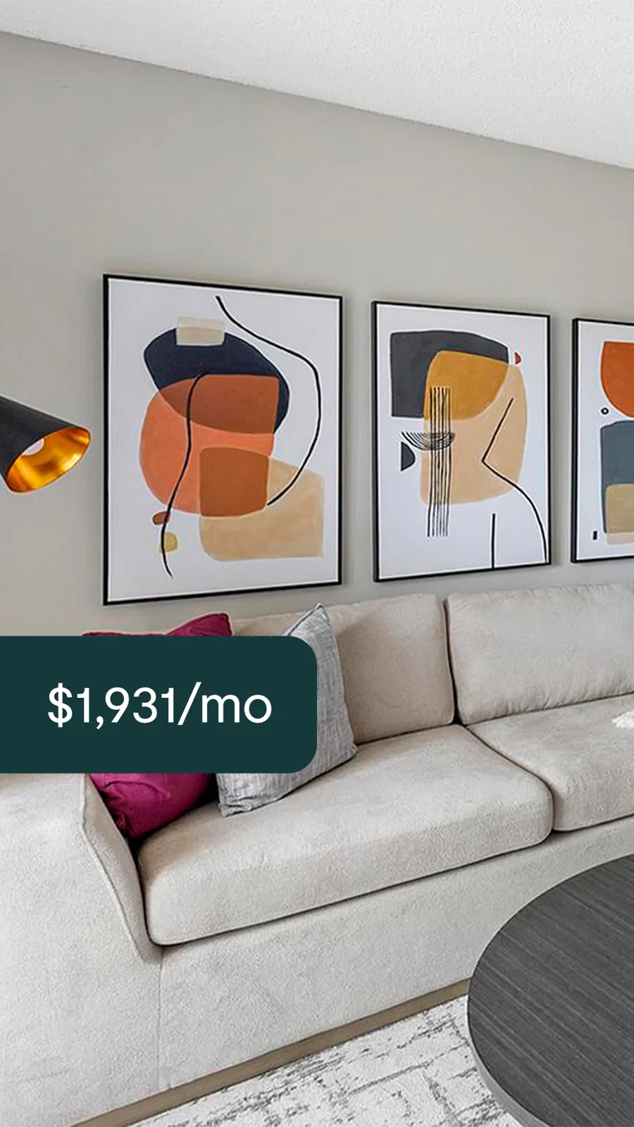 A tall ad: a pale sofa under three abstract prints in orange and black, a dark tab with the monthly rent.
