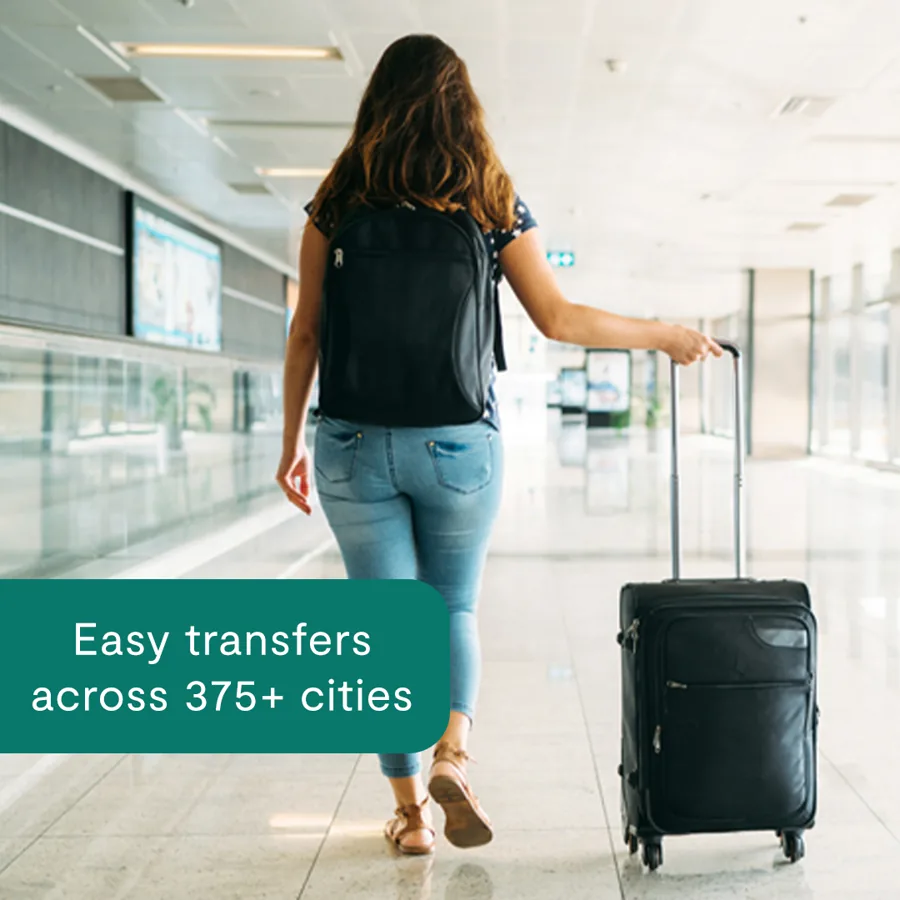 A square ad: a woman with a backpack wheels a suitcase through a bright airport, a green tab promising easy transfers across hundreds of cities.