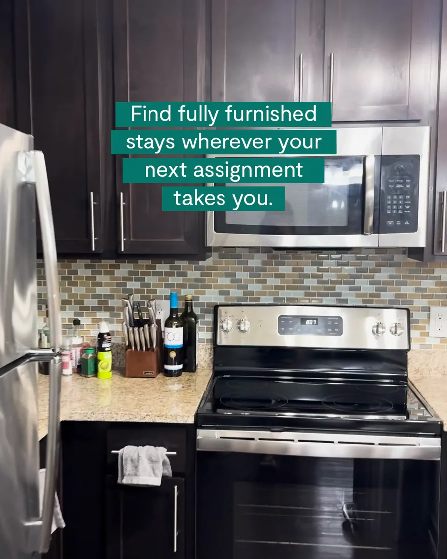A video still: an apartment kitchen with dark cabinets and a steel stove, captions in green bars about furnished stays wherever your next assignment takes you.